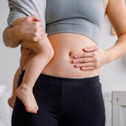 Woman holding child after c-section-recovery